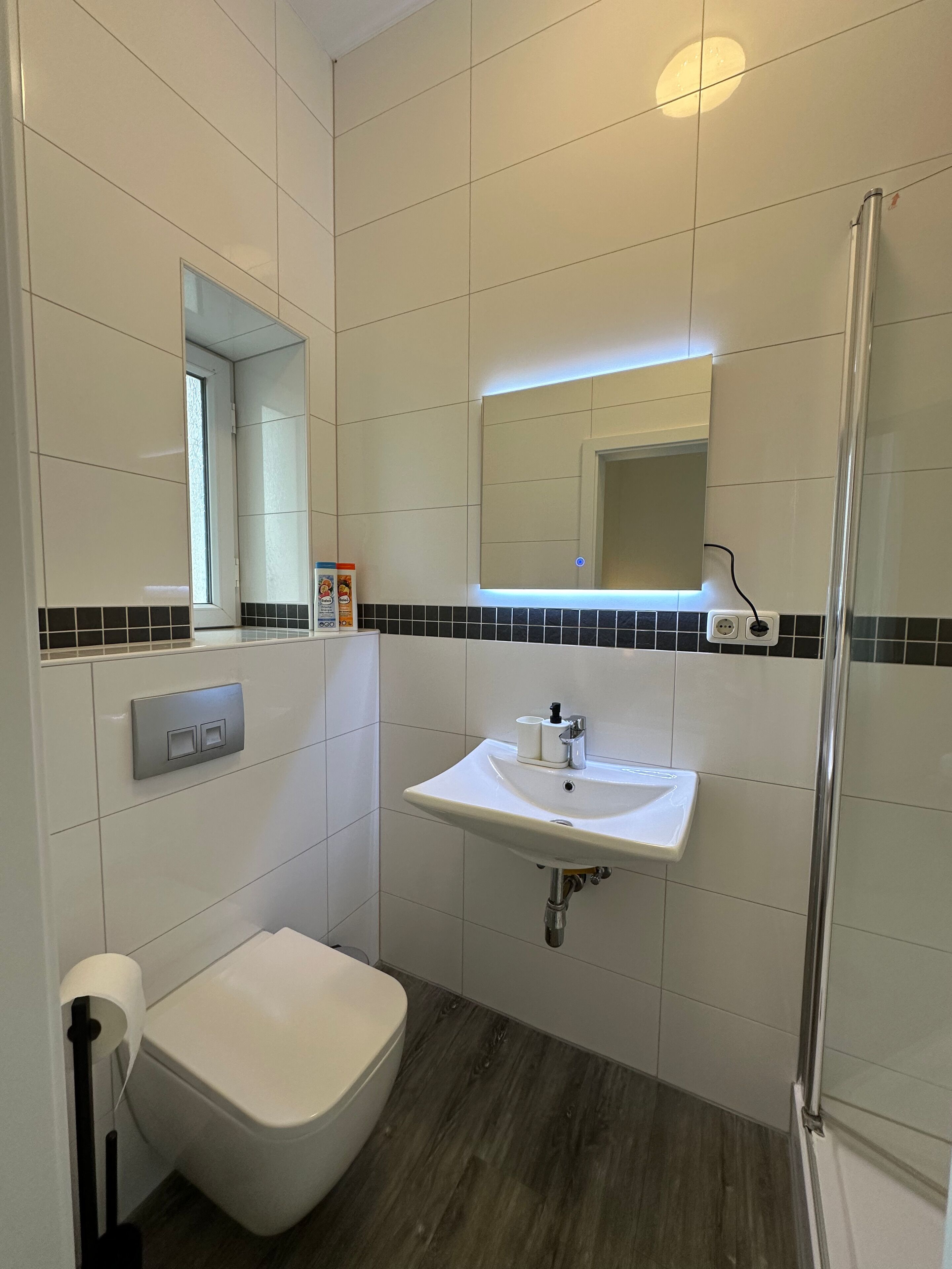 Un bagno con il water, un lavandino e uno specchio.