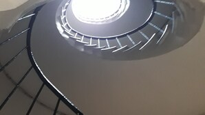 Eine Wendeltreppe mit einer zentralen Leuchte.