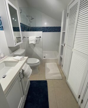 A bathroom with a toilet, sink, and shower.