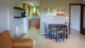 Un espacio habitable compacto con cocina, comedor y sofá.