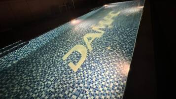 Enjoy a refreshing swim in the pool with a unique checkered tile design.