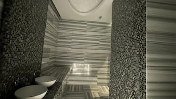 Bathroom features two sinks, mosaic tile walls, and a striped floor.