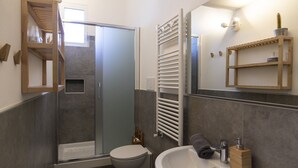 A modern bathroom with a shower, two toilets, a sink, and a mirror. - Family room with 2 double or twin rooms near the port and the Venice district. (Livorno)