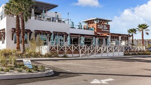 A modern restaurant with outdoor seating, a sign indicating 'Open Now', and a view of the street. - Stay Longer, Save More (Fernandina Beach)