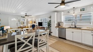 A modern kitchen with white cabinets, a wooden countertop, and a ceiling fan. - Stay Longer, Save More (Fernandina Beach)