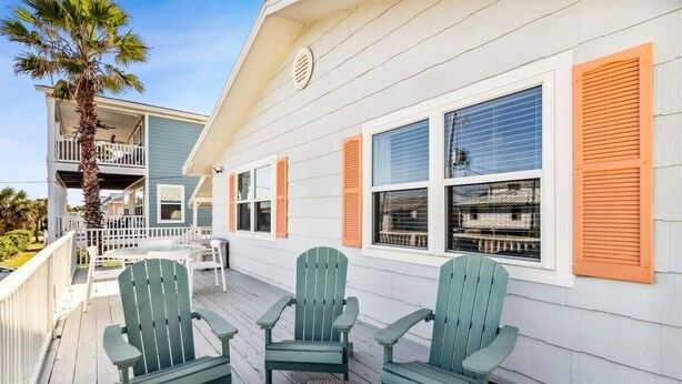 A wooden deck with green Adirondack chairs and a round table. - Perfect for Projects, Travels, or Transitions (Fernandina Beach)