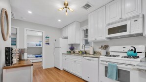A modern kitchen with white cabinetry, a stainless steel refrigerator, a gas stove, and a microwave. - Professionally Managed | 3 Blocks to Beach (Seaside Heights)