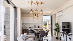 Una sala de estar moderna con sofá, mesa de centro, comedor, cocina y televisión.