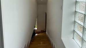 A narrow hallway with wooden flooring, white walls, and a window with decorative glass panels. - Maison de Ville Avec Grand Jardin (Chennevières-sur-Marne)