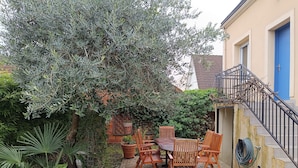 A patio with a table and chairs, surrounded by greenery and a brick wall. - Maison de Ville Avec Grand Jardin (Chennevières-sur-Marne)
