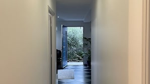A hallway with a checkered floor leading to a door and a view of greenery outside. - Maison de Ville Avec Grand Jardin (Chennevières-sur-Marne)