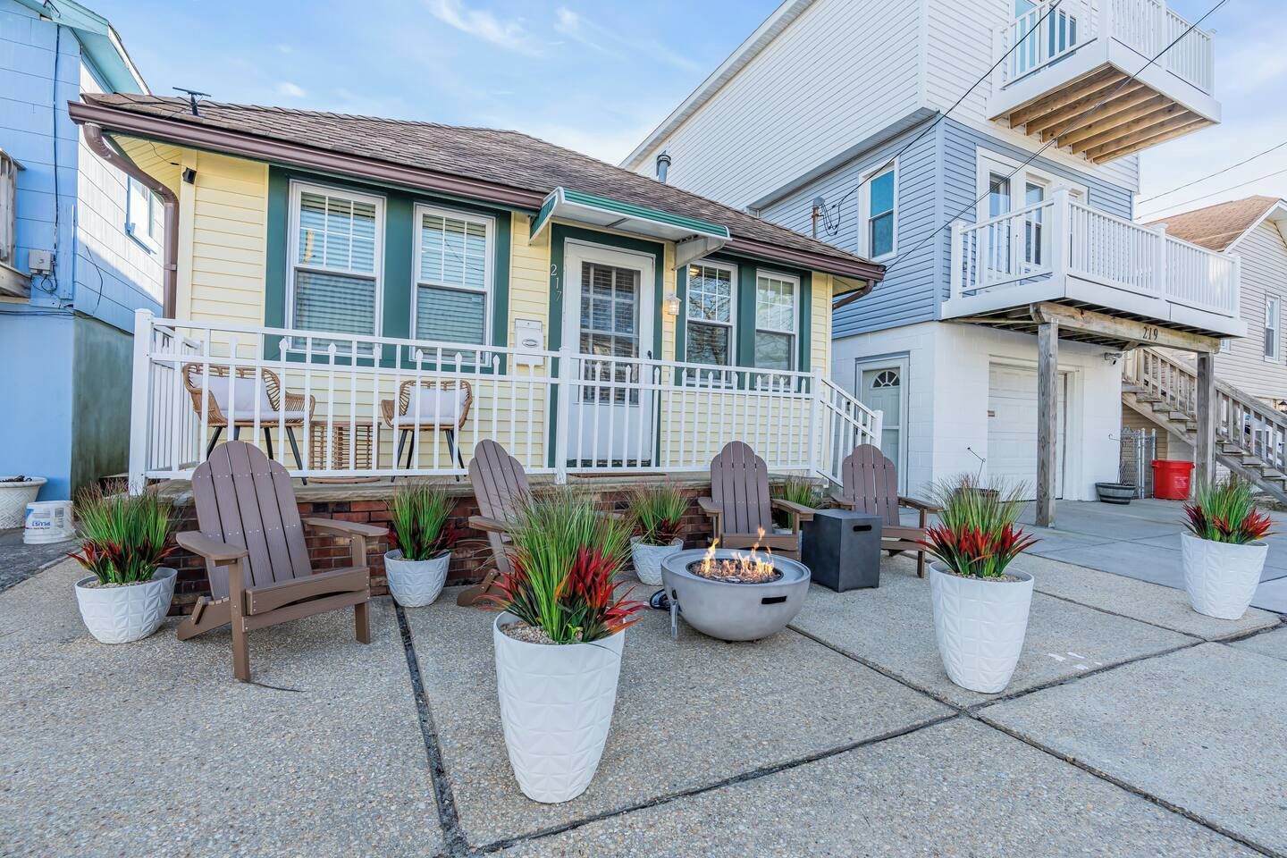 A residential property with a porch, outdoor seating, and a fire pit.