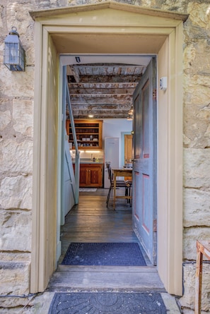 Staircase leads to a rustic kitchen with dining area.