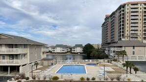 A residential area with a swimming pool, a dock, and a body of water. - Tilghman Lakes By the Sea (North Myrtle Beach)
