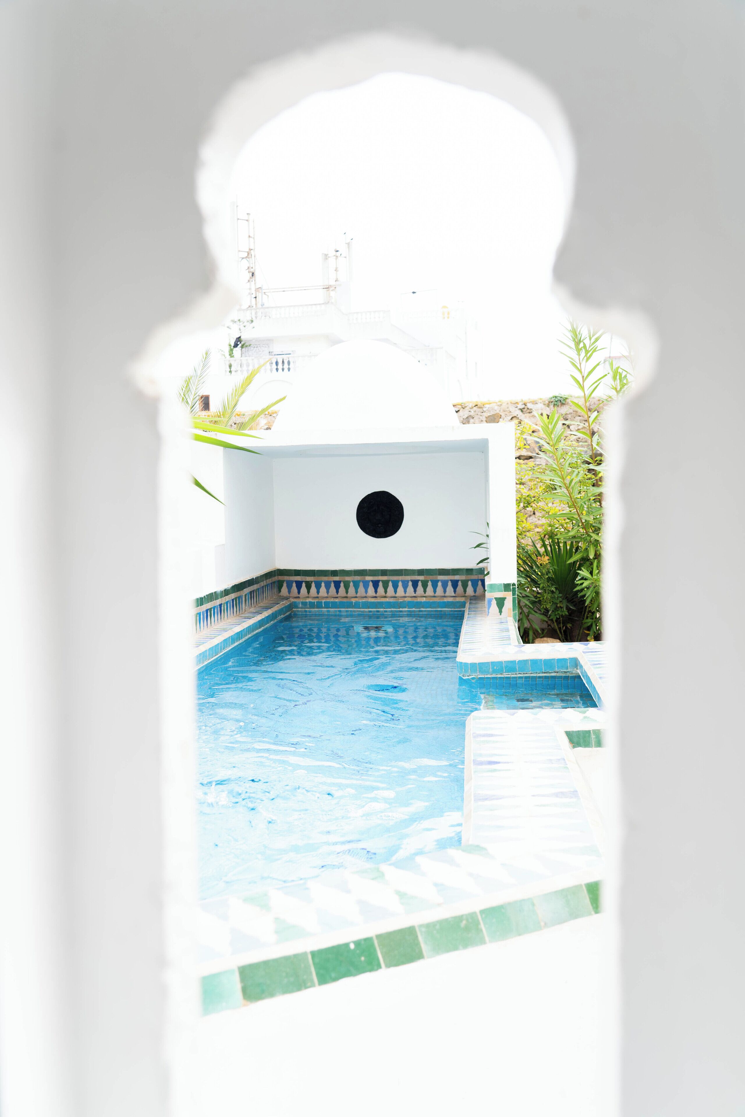 Una piscina amb un videt de rajola i una finestra rodona.