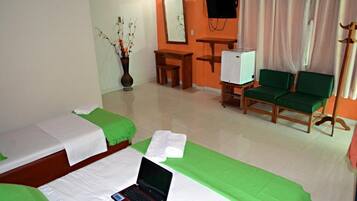 A hotel room with two beds, a desk, a television, and a chair.