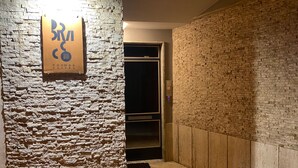 Un mur de briques avec une enseigne indiquant « Bri » et « Chambres et suites ».