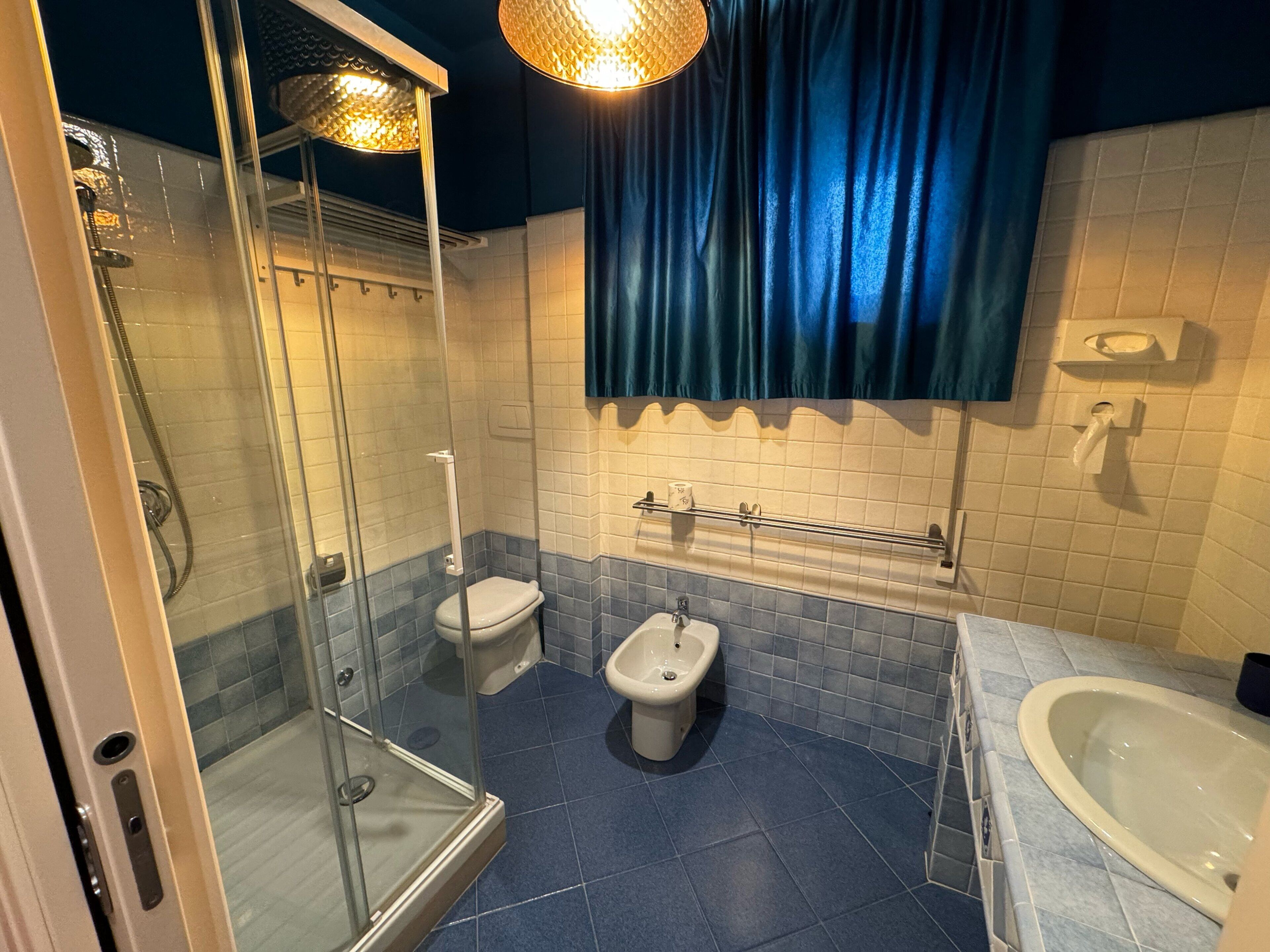A bathroom with a glass-enclosed shower, a toilet, a bidet, and a bathtub.