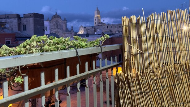 Un balcon donnant sur un bâtiment historique et agrémenté d’une clôture en bambou.