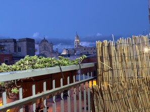 Un balcón con vistas a un edificio histórico y una valla de bambú.
