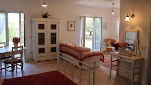 Un dormitorio con cama, escritorio, silla, armario y espejo.