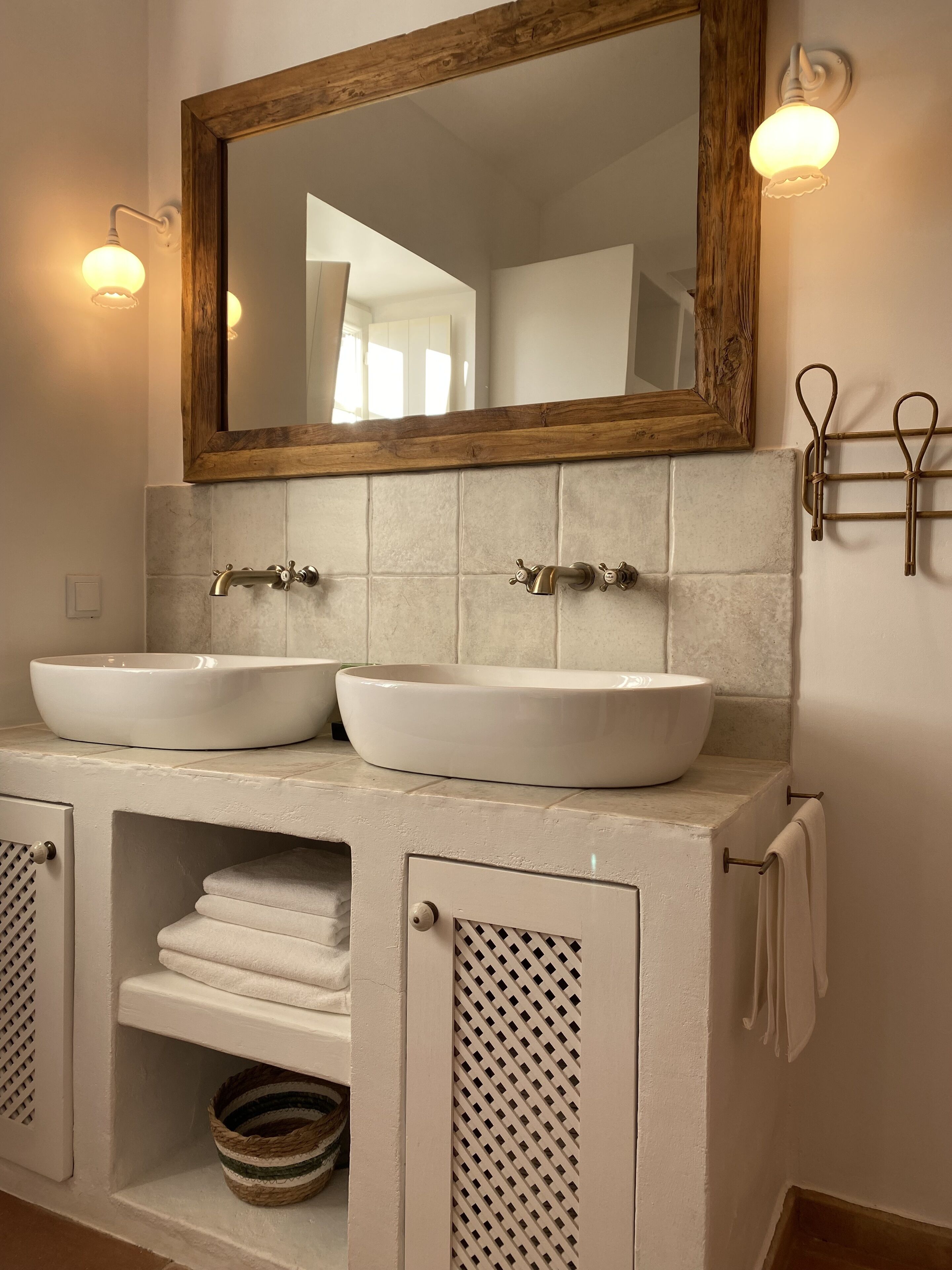 A bathroom with two sinks, a mirror, and a towel rack.