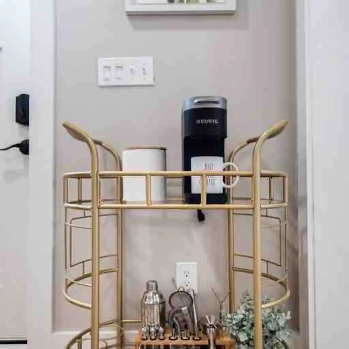 A bunk bed with a metal frame, a black heater on the wall, and a small table with a bottle and a decorative item.