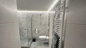 A modern bathroom with a shower, toilet, and towel rack. - Relaxen im Weindorf Mayschoß Fewo 1 (Mayschoß)