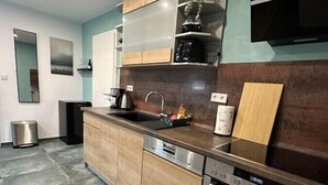 A modern kitchen with a stainless steel oven, a built-in dishwasher, and a wooden countertop. - Relaxen im Weindorf Mayschoß Fewo 3 (Mayschoß)