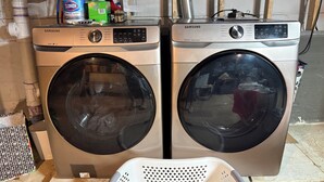 Deux lave-linge Samsung à chargement frontal, avec un tambour en plastique blanc visible à l’avant.