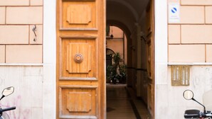 An arched entrance to a building with a wooden door and a brick wall. - 3 DOUBLE ROOMS IN THE CENTER OF ROME! (Roma)