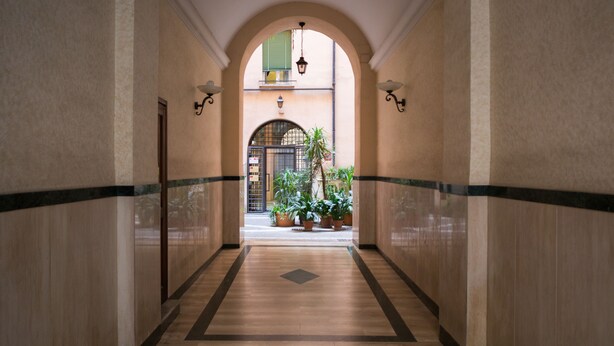 A corridor with a tiled floor, a central archway, and potted plants. - 3 DOUBLE ROOMS IN THE CENTER OF ROME! (Roma)