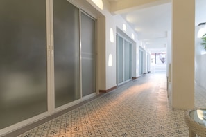 Corridors lead to inviting doors with frosted glass designs, set against a light-colored backdrop.
