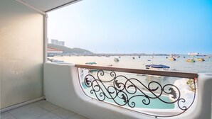 A balcony with a view of a beach and boats. - Windy Inn (Pattaya)