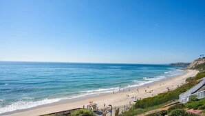 Une plage avec un ciel dégagé, un rivage sablonneux et une tour de surveillance des sauveteurs.