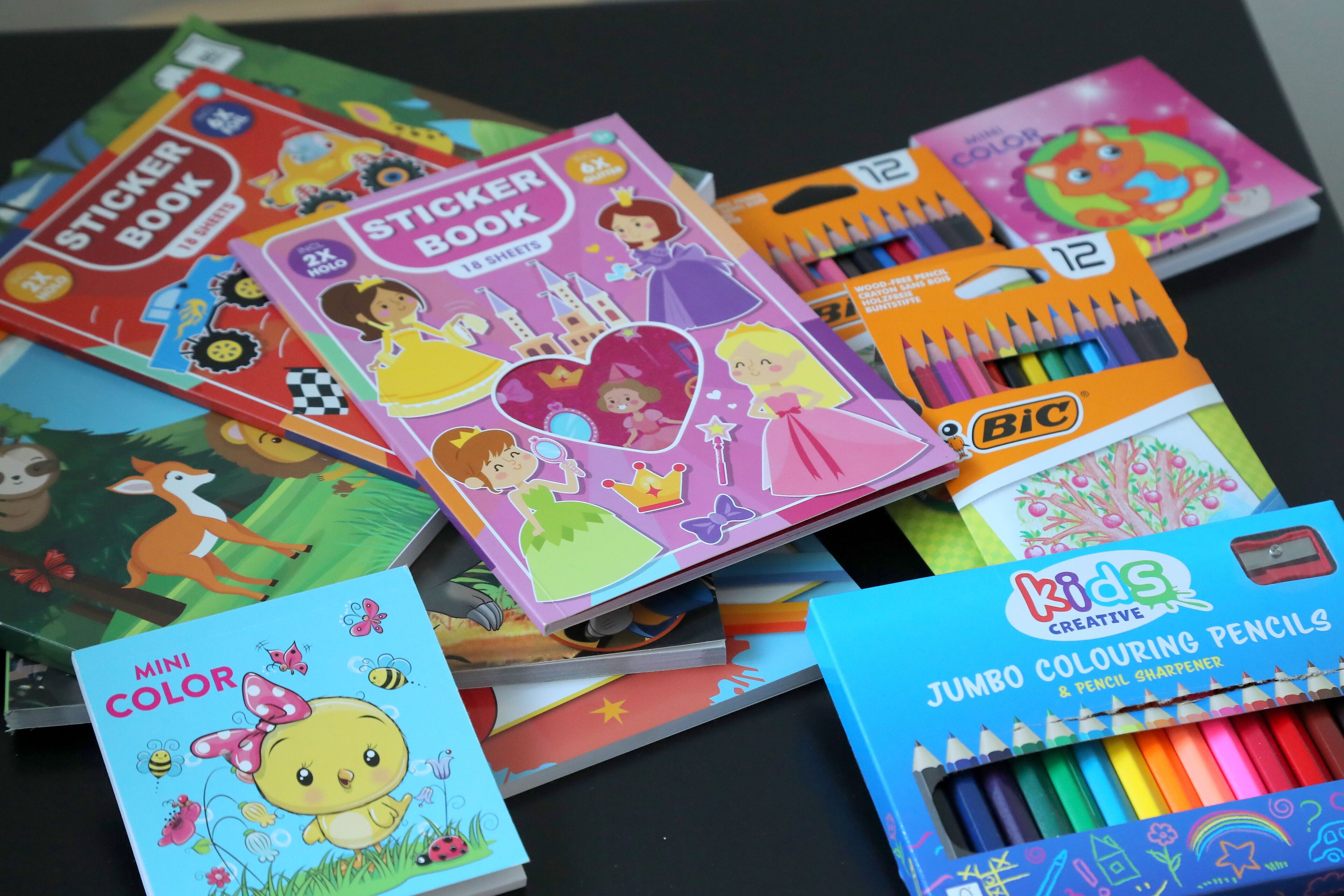 A variety of children's coloring books and coloring supplies.