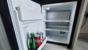 Un réfrigérateur ouvert, avec des étagères et un compartiment congélateur.
