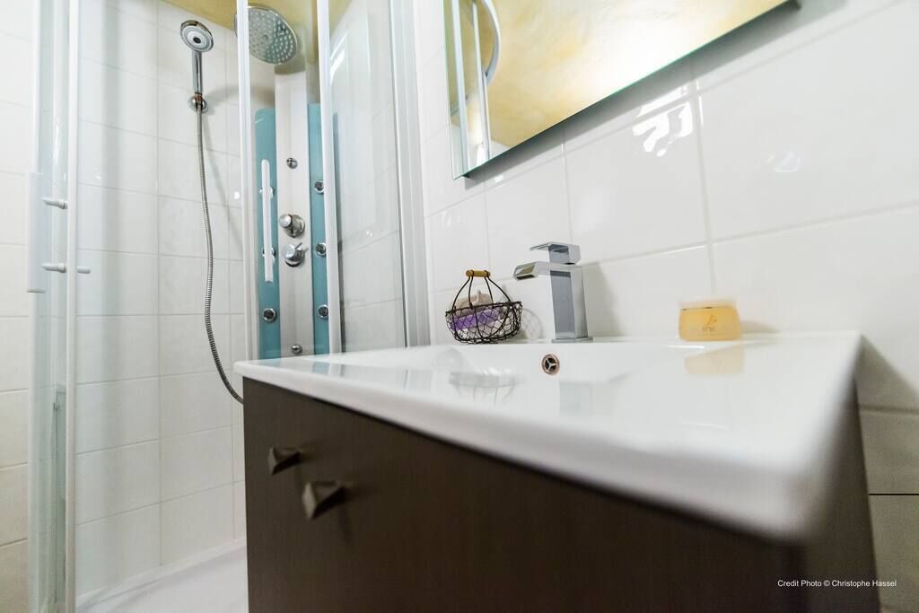 Ein Badezimmer mit Dusche, Waschbecken und Spiegel.
