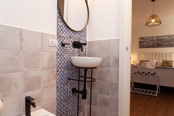 A bathroom with a white sink, black faucet, and a towel rack. - Villa Seven Palms (Isola delle Femmine)