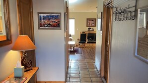 A hallway with a wooden desk, a lamp, a patterned rug, and a fireplace in the background. - Dog Friendly 2B/2Ba Townhome near Moab Golf Course (Moab)