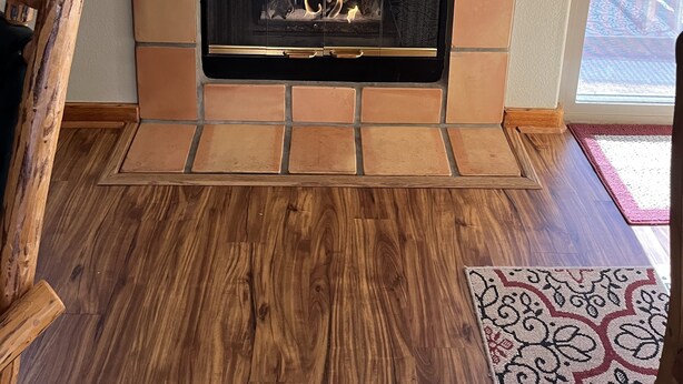 A fireplace with a stone surround, a framed artwork above it, and a wooden floor. - Dog Friendly 2B/2Ba Townhome near Moab Golf Course (Moab)