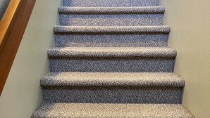 A carpeted staircase with wooden handrails and a light-colored wall. - Dog Friendly 2B/2Ba Townhome near Moab Golf Course (Moab)