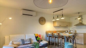 Een moderne woonkamer met een bank, salontafel en een eethoek met stoelen en een tafel.