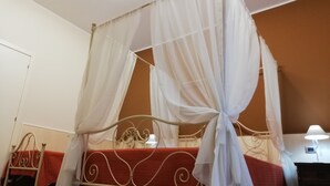 Una cama con dosel, una mesita de noche y una lámpara.