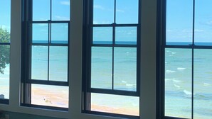 Una habitación con tres ventanas amplias que ofrecen vista al océano.