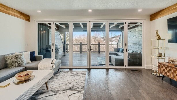 A spacious living room with a large sliding glass door leading to an outdoor deck.