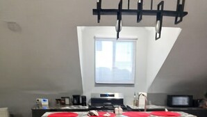 Una cocina moderna con una isla central, sillas negras y una lámpara colgante.