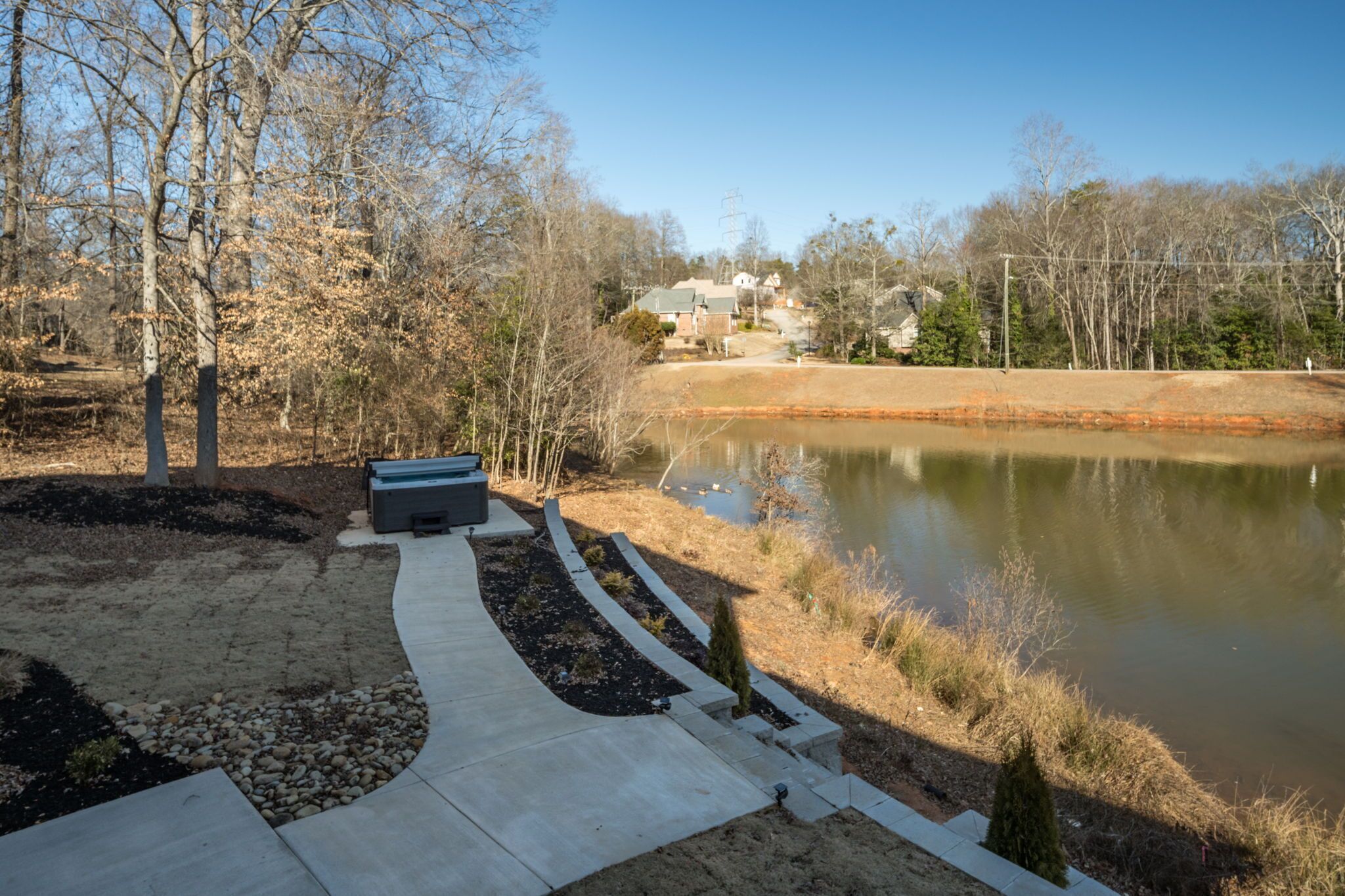 A park with a pond, pathways, benches, and trees.