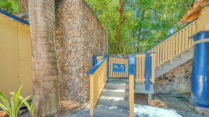 Eine Treppe mit Steinmauer und blauer Handlauf, die zu einer höheren Ebene führt.