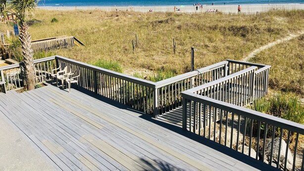 Una pasarela de madera que conduce a una playa con vista despejada al océano.